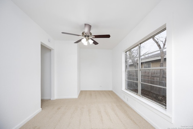 unfurnished room with ceiling fan and light carpet