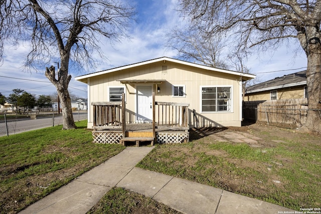 view of front of house with a wooden deck and a front yard