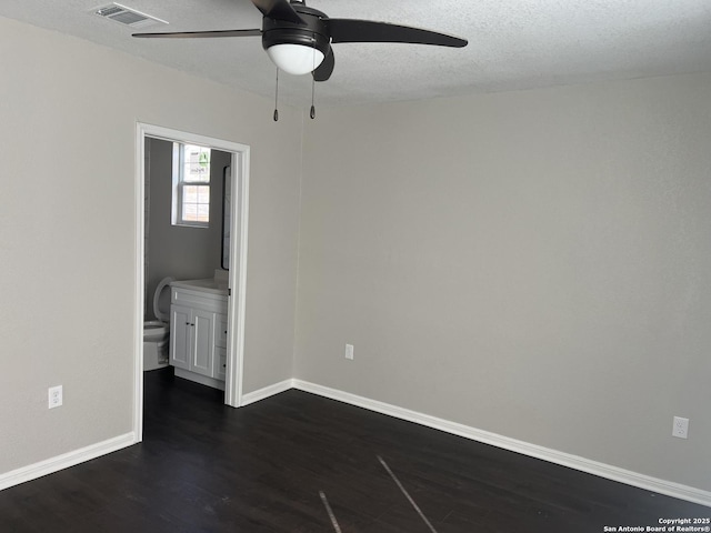 unfurnished room with ceiling fan, dark wood-type flooring, and a textured ceiling