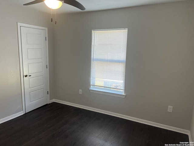 empty room featuring dark wood-type flooring and ceiling fan