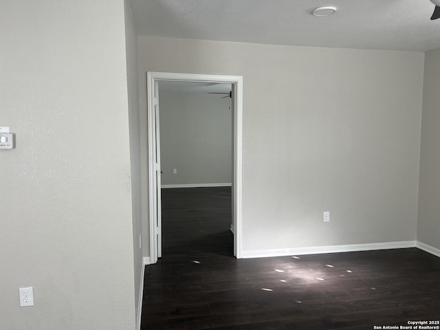 spare room featuring dark wood-type flooring and ceiling fan