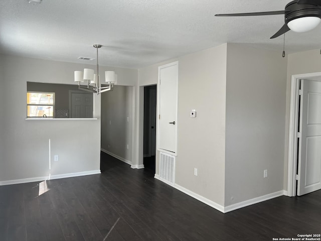 unfurnished room featuring ceiling fan with notable chandelier, a textured ceiling, and dark hardwood / wood-style flooring