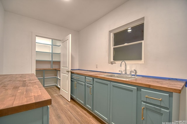 kitchen featuring sink, light hardwood / wood-style floors, and wooden counters