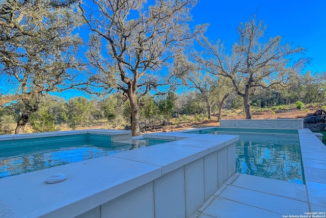 view of pool with a jacuzzi