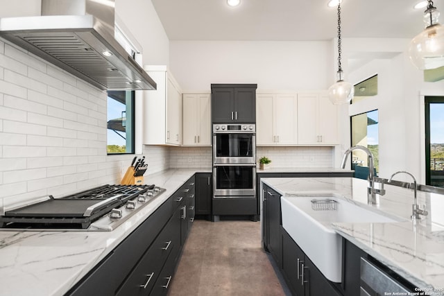 kitchen with white cabinets, appliances with stainless steel finishes, pendant lighting, and ventilation hood