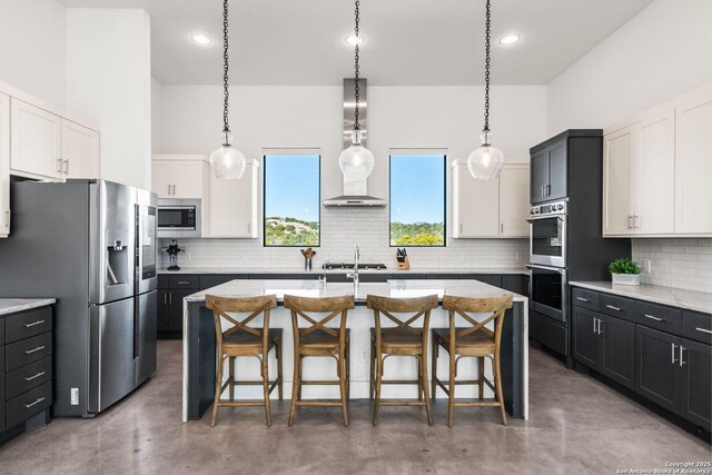 kitchen with stainless steel appliances, white cabinetry, and dark cabinets