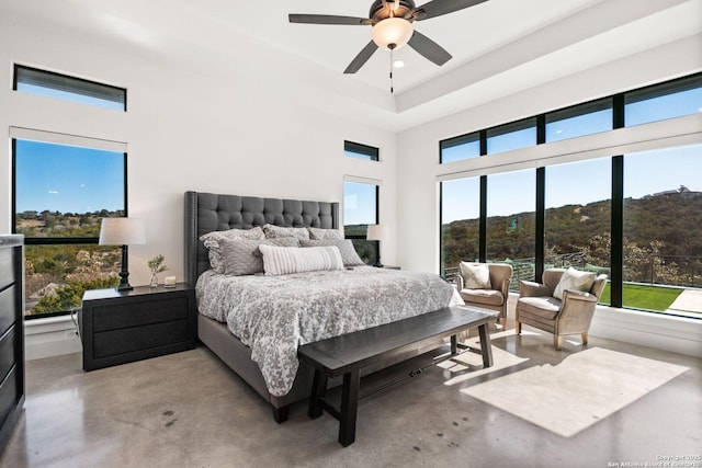 bedroom featuring concrete floors, a high ceiling, and a ceiling fan