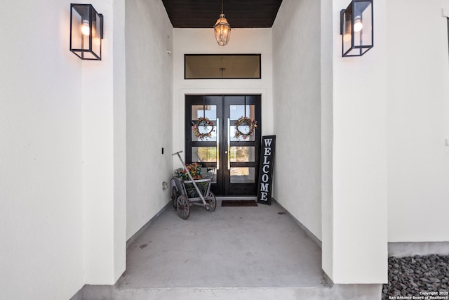 entrance to property featuring stucco siding and french doors