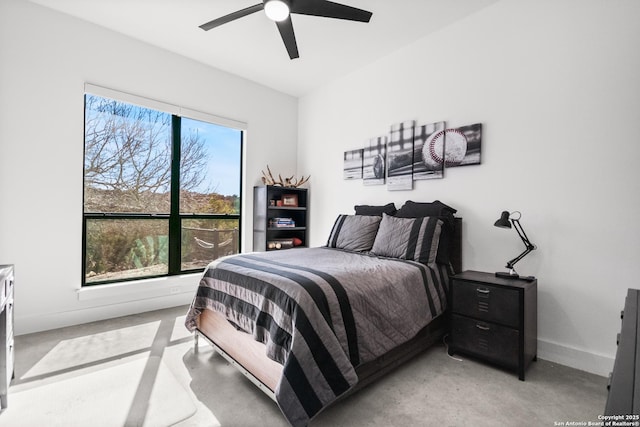 bedroom featuring baseboards, concrete flooring, and a ceiling fan