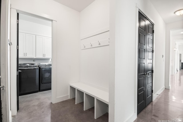 mudroom featuring washing machine and dryer, concrete floors, and baseboards