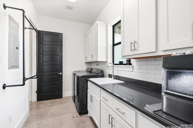 laundry room with cabinet space, baseboards, visible vents, washer and dryer, and a sink