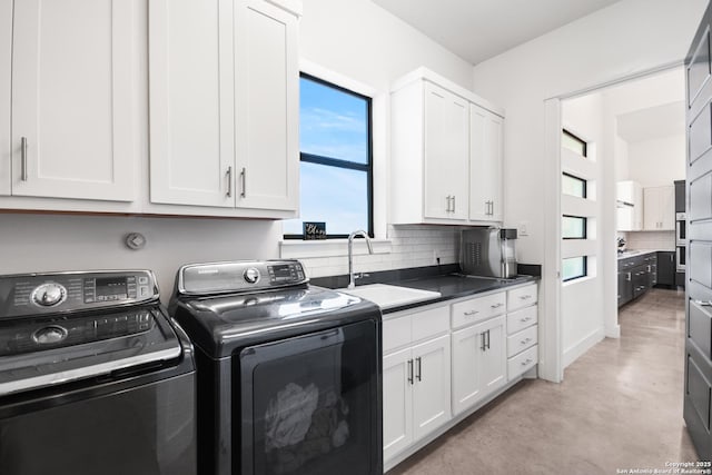 laundry area featuring washer and clothes dryer, a sink, and cabinet space