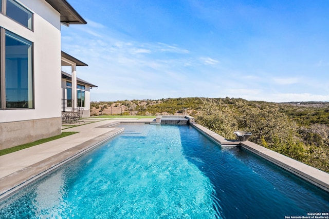 view of pool with a pool with connected hot tub and a patio