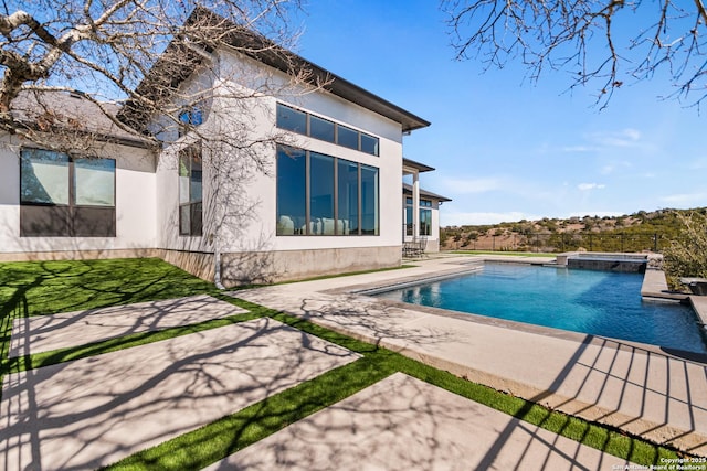 view of swimming pool with a pool with connected hot tub and a patio