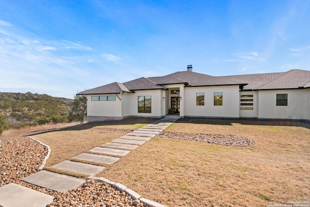 prairie-style home with a front lawn and stucco siding