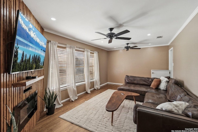 living room featuring hardwood / wood-style flooring, ceiling fan, and crown molding