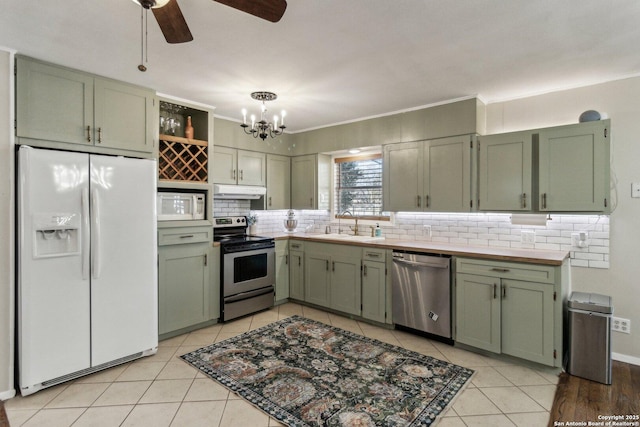 kitchen featuring appliances with stainless steel finishes, sink, and green cabinetry