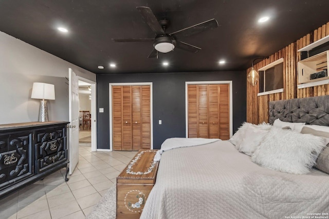 bedroom featuring multiple closets, light tile patterned flooring, and connected bathroom