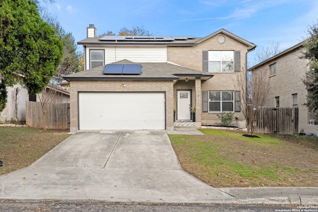 front of property featuring a garage, a front lawn, and solar panels