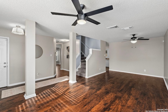 unfurnished living room with dark wood-type flooring and a textured ceiling