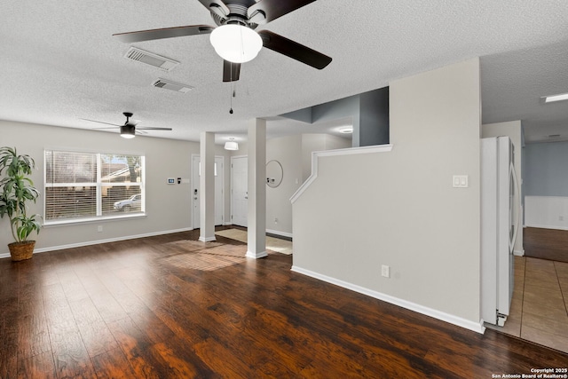 unfurnished living room featuring a textured ceiling and dark hardwood / wood-style flooring