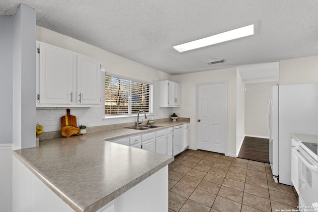 kitchen featuring sink, kitchen peninsula, white appliances, decorative backsplash, and white cabinets