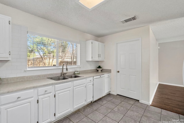 kitchen with tasteful backsplash, sink, white cabinets, and white dishwasher