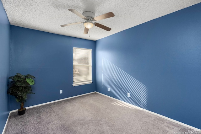 carpeted empty room with ceiling fan and a textured ceiling