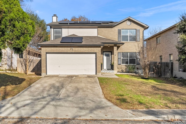 front of property with a garage, a front lawn, and solar panels