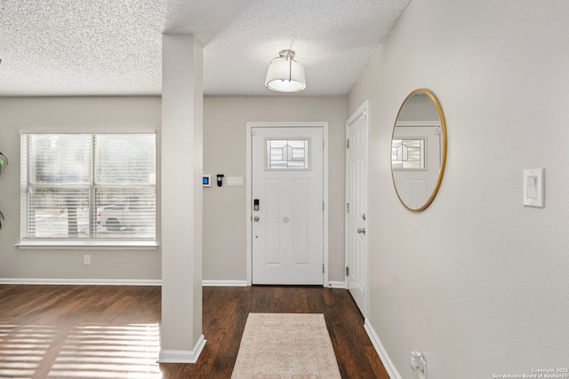 foyer entrance with dark hardwood / wood-style flooring and a textured ceiling