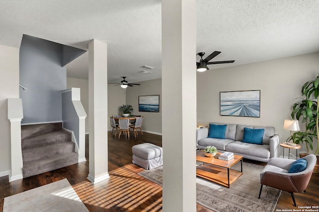 living room with dark wood-type flooring, a textured ceiling, and ceiling fan