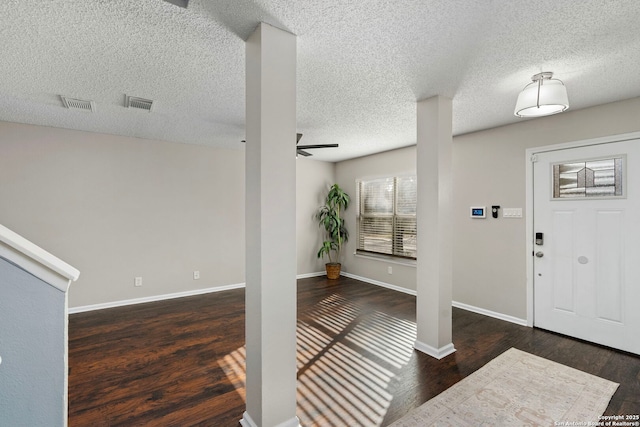 foyer entrance with a textured ceiling, dark hardwood / wood-style floors, and ceiling fan