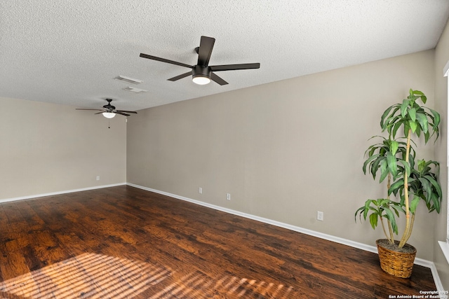 empty room with dark wood-type flooring and a textured ceiling