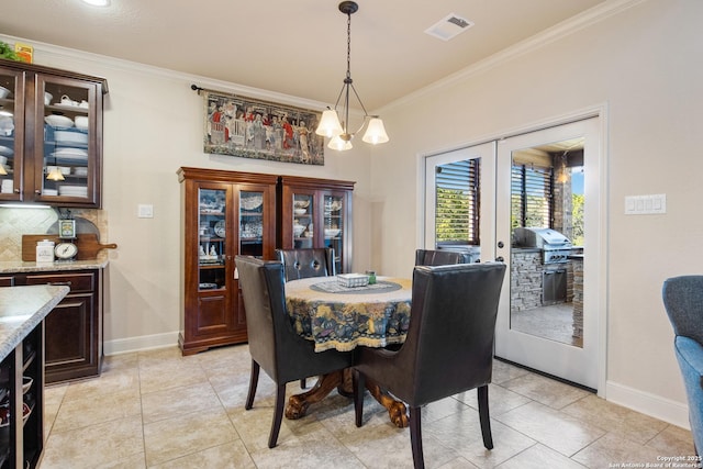 tiled dining room with crown molding and french doors