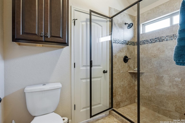 bathroom featuring toilet and tiled shower