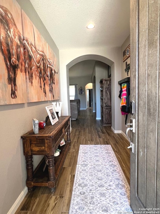 hall featuring dark wood-type flooring and a textured ceiling