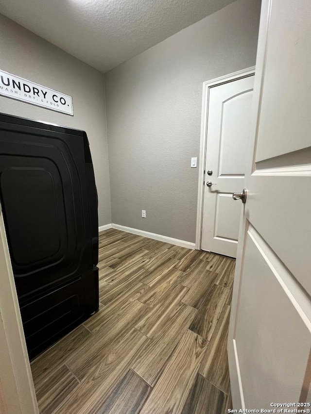 unfurnished office with wood-type flooring and a textured ceiling