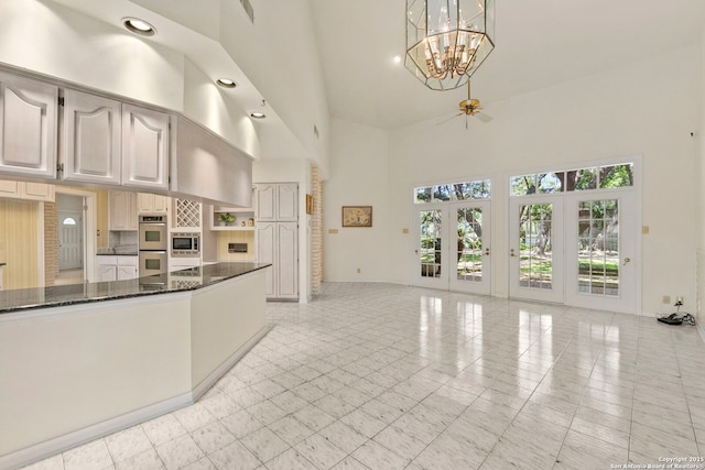 311 Ridge Blf, San Antonio, TX 78216 - kitchen featuring a towering ceiling, stainless steel appliances, a chandelier, baseboards, and dark stone countertops