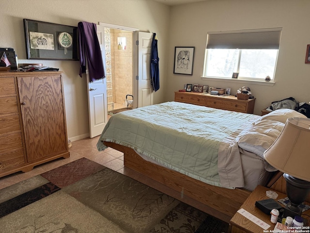 bedroom with light tile patterned flooring and connected bathroom