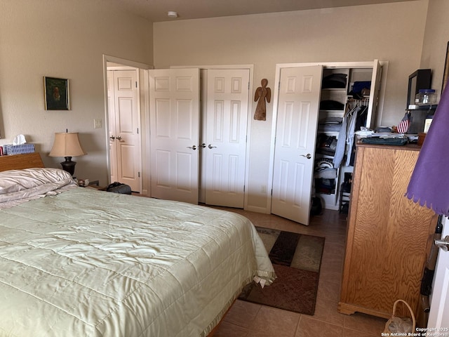 tiled bedroom featuring multiple closets