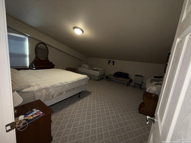 carpeted bedroom featuring lofted ceiling and a textured ceiling