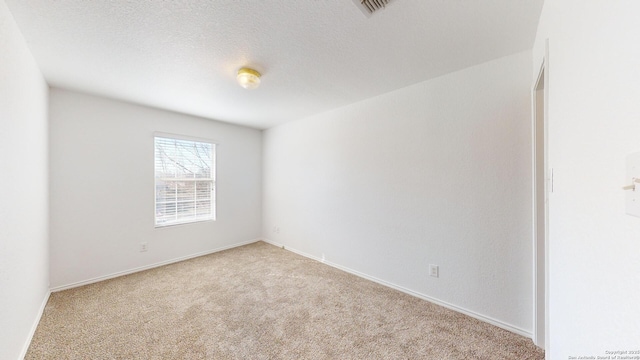 carpeted spare room featuring a textured ceiling