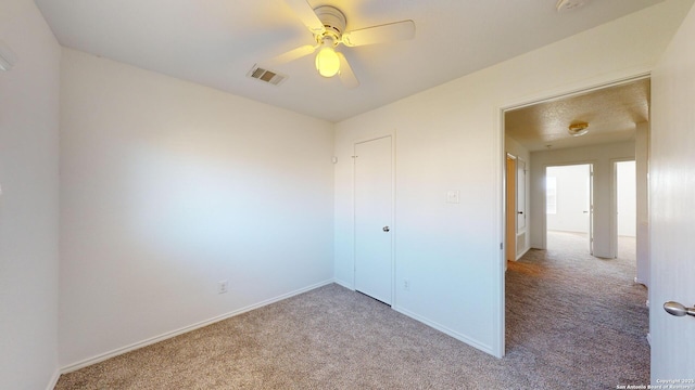 unfurnished bedroom featuring light carpet and ceiling fan