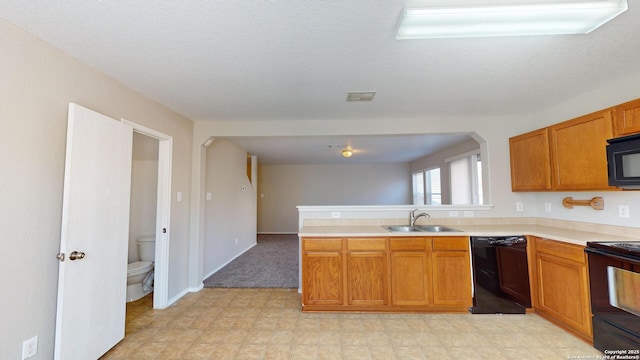 kitchen with sink, kitchen peninsula, a textured ceiling, and black appliances