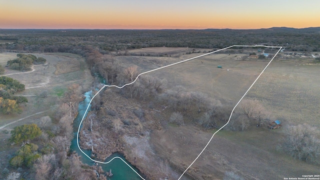 aerial view at dusk featuring a rural view and a mountain view