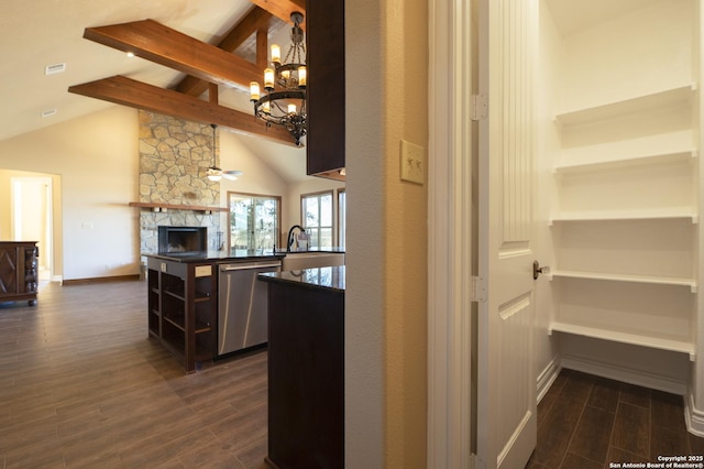 kitchen featuring dishwasher, an inviting chandelier, a fireplace, dark hardwood / wood-style flooring, and beamed ceiling