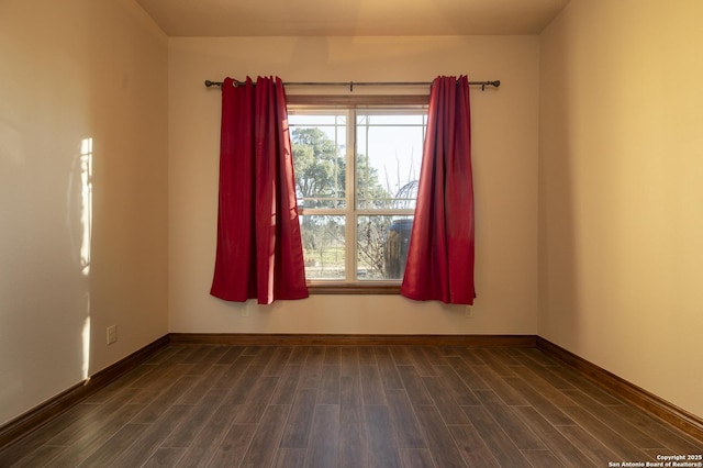 empty room with dark wood-style floors and baseboards