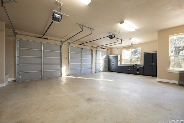 garage with baseboards and a garage door opener