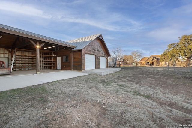 view of home's exterior with an outbuilding, metal roof, an exterior structure, and a garage