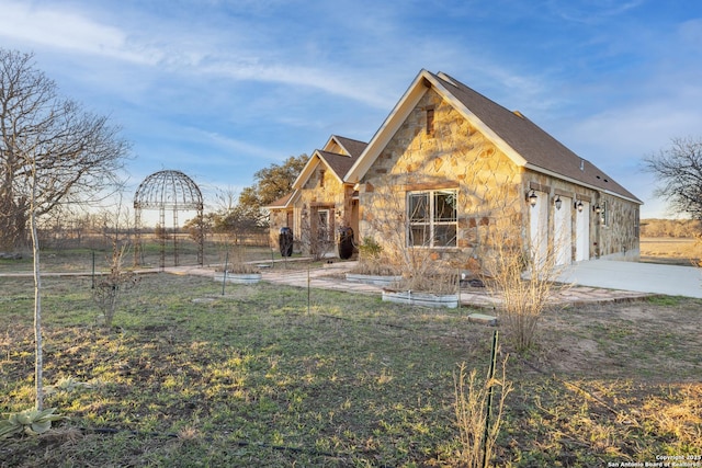 view of home's exterior featuring stone siding and concrete driveway